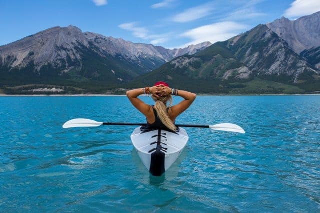 Girl Relaxing on kayak in clear blue water