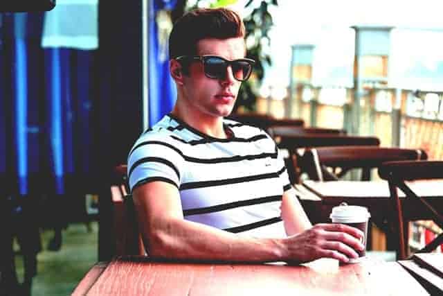 Young man sitting at coffee shop with sunglasses