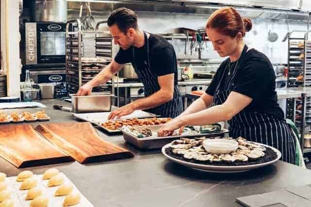 Adult chefs in kitchen preparing sea food