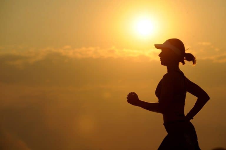 Staying Fit Silhouette of women jogging in sunset with clouds