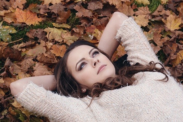 girl lying in leaves on ground