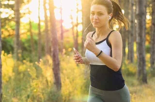 Staying Fit Woman jogging outdoors with trees