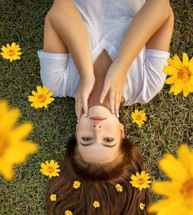 Morning Affirmations beautiful women on grass with yellow daisy flowers around